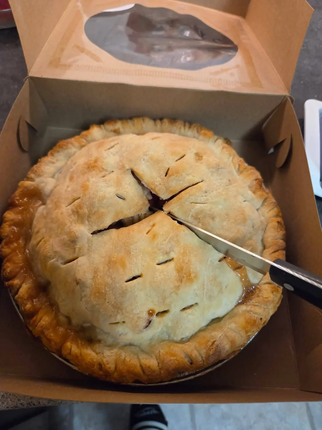 An apple pie in an open bakery box
