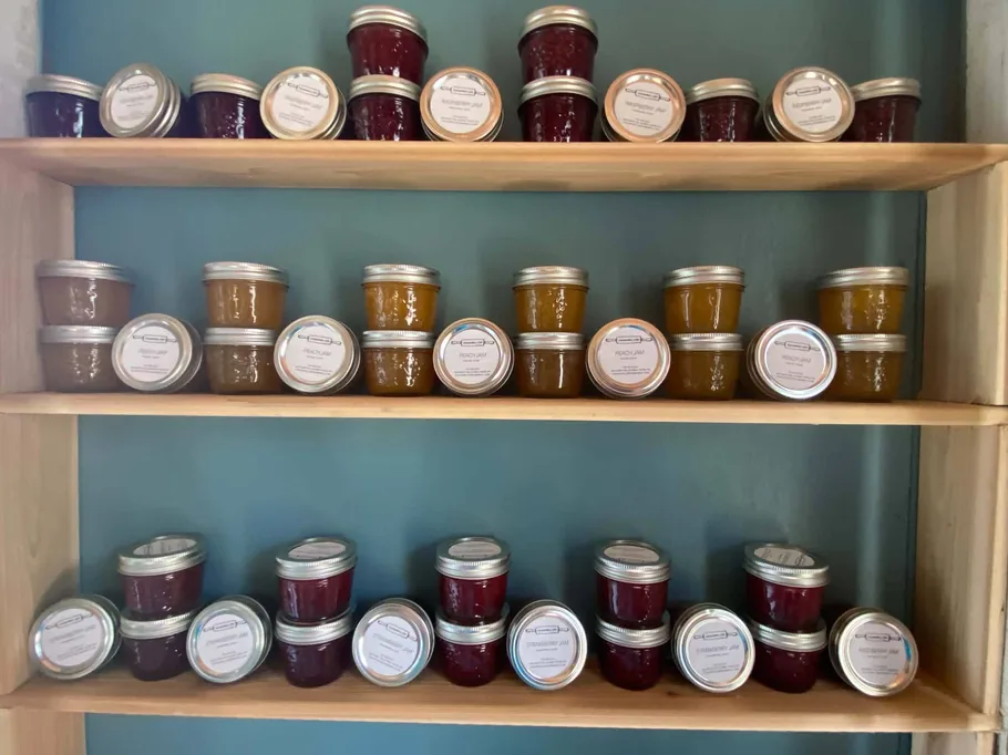 Rows of labelled preserve jars on wooden shelving